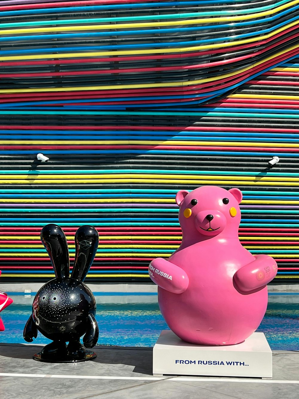 a sculpture of a pink bear and a black bunny
