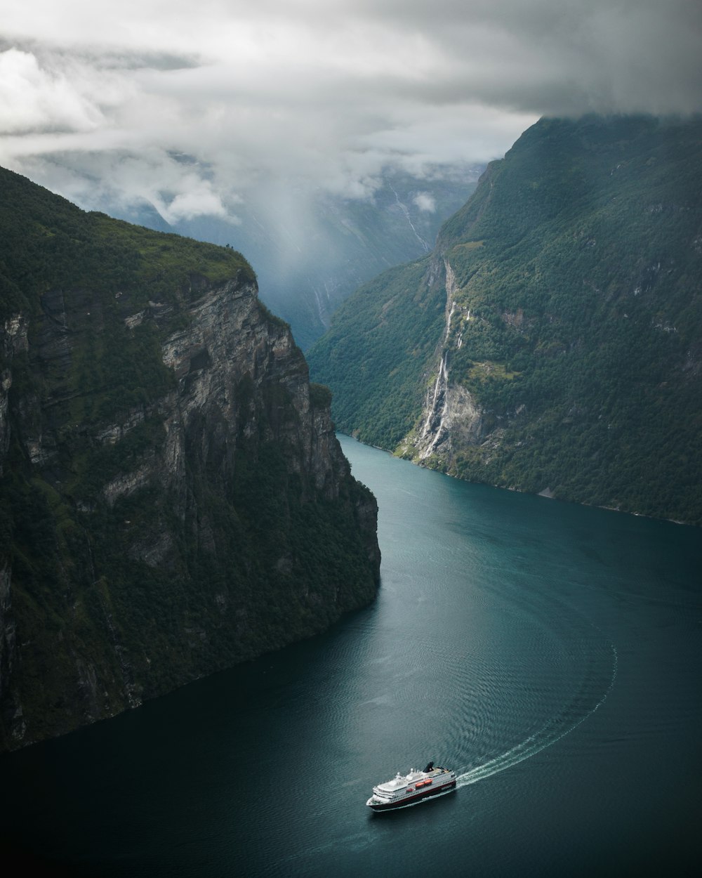 a boat in a body of water surrounded by mountains