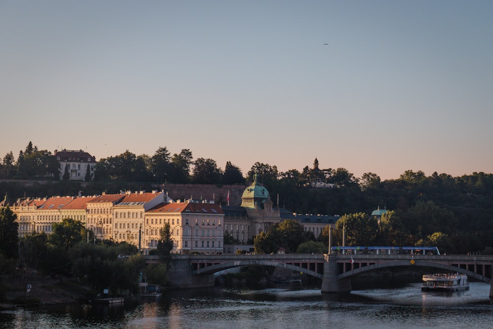 a bridge over a river with a city in the background