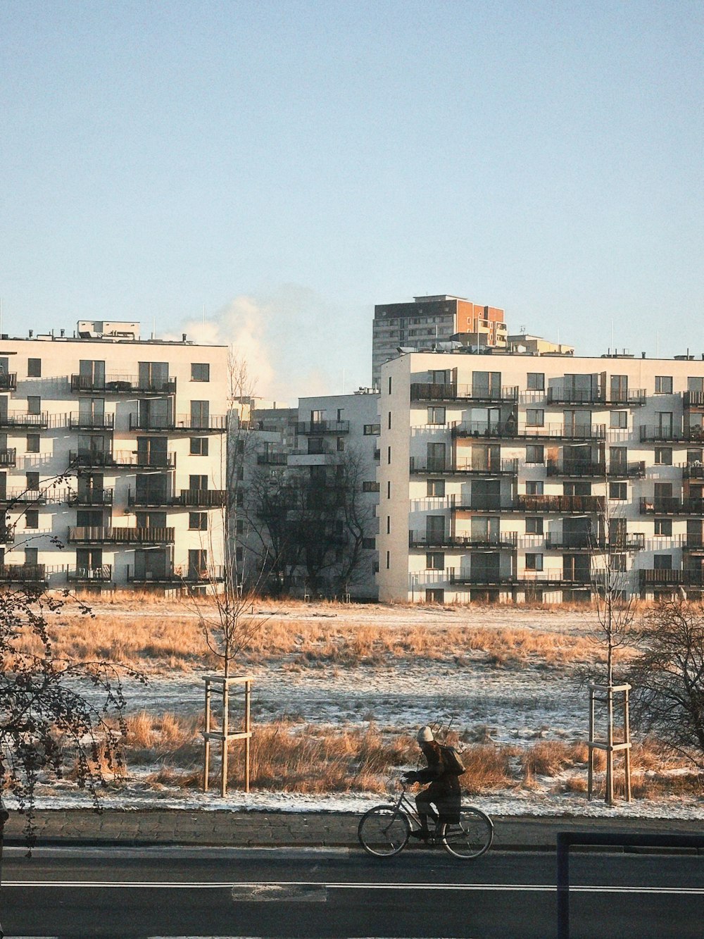 a man riding a bike down a street next to tall buildings