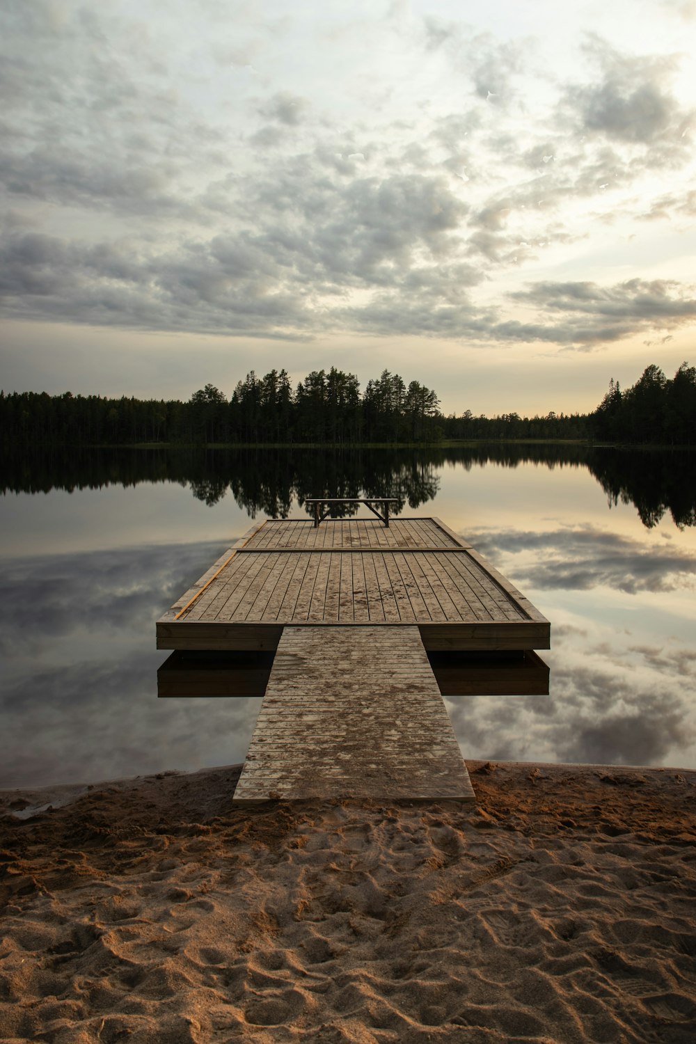 a dock sitting on top of a sandy beach