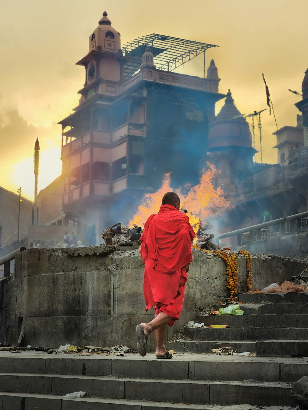 a man in a red robe walking up some steps