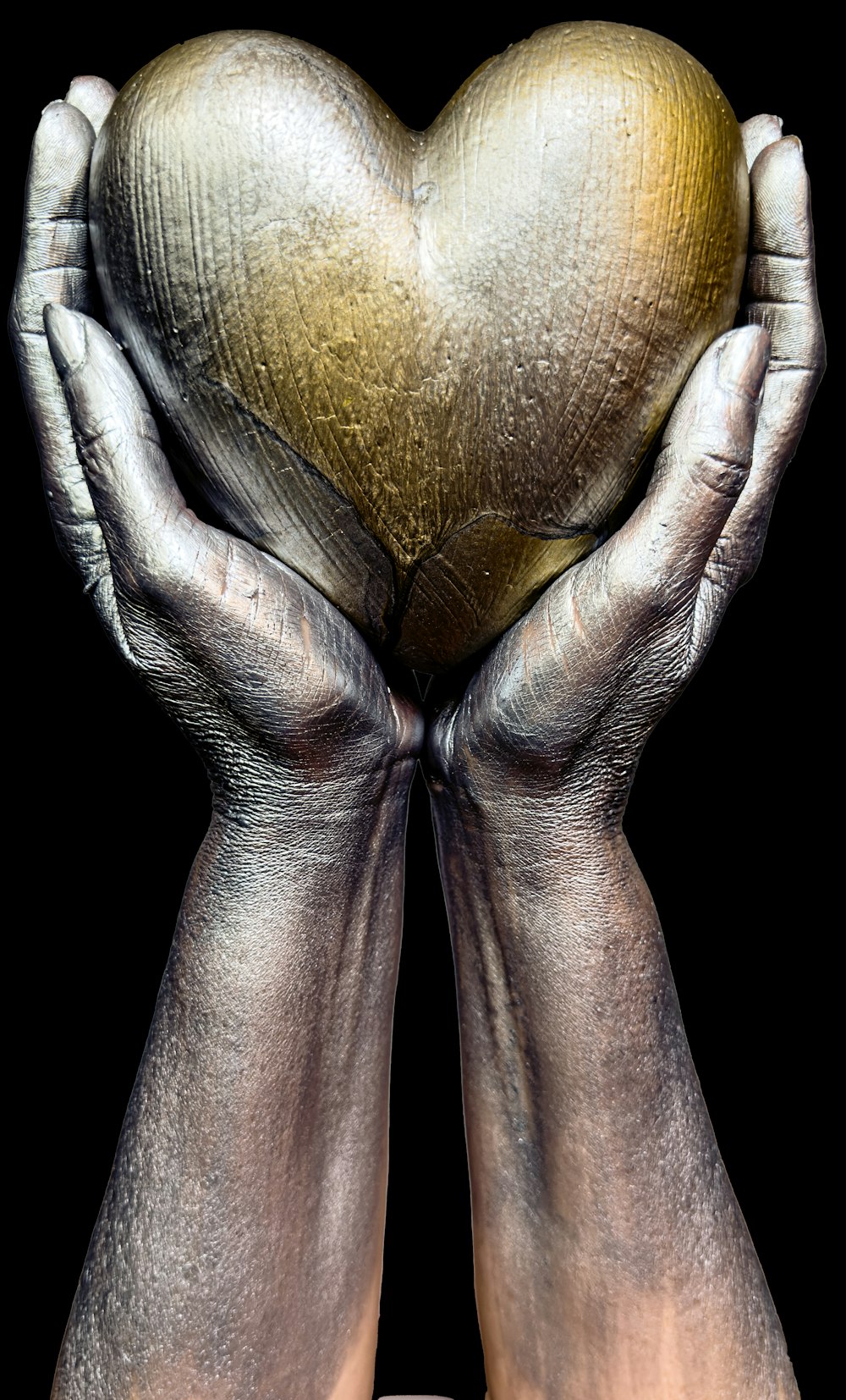 a pair of hands holding a golden heart