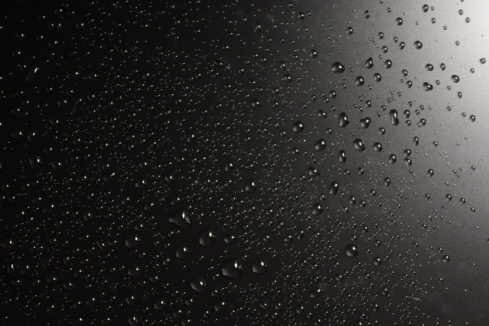 a black and white photo of rain drops on a window