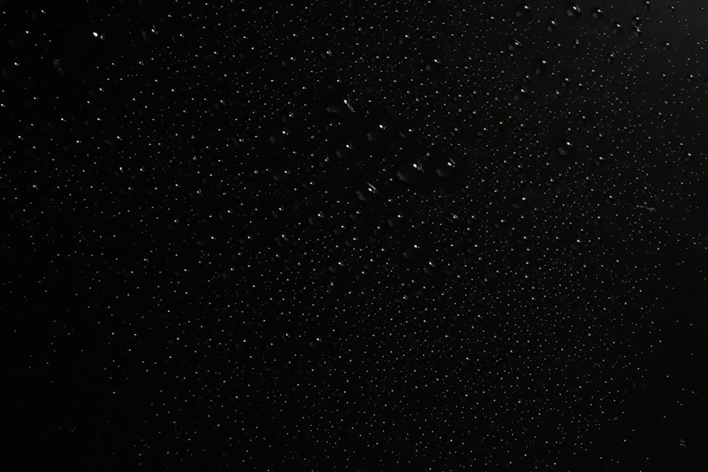 a black background with a lot of drops of water