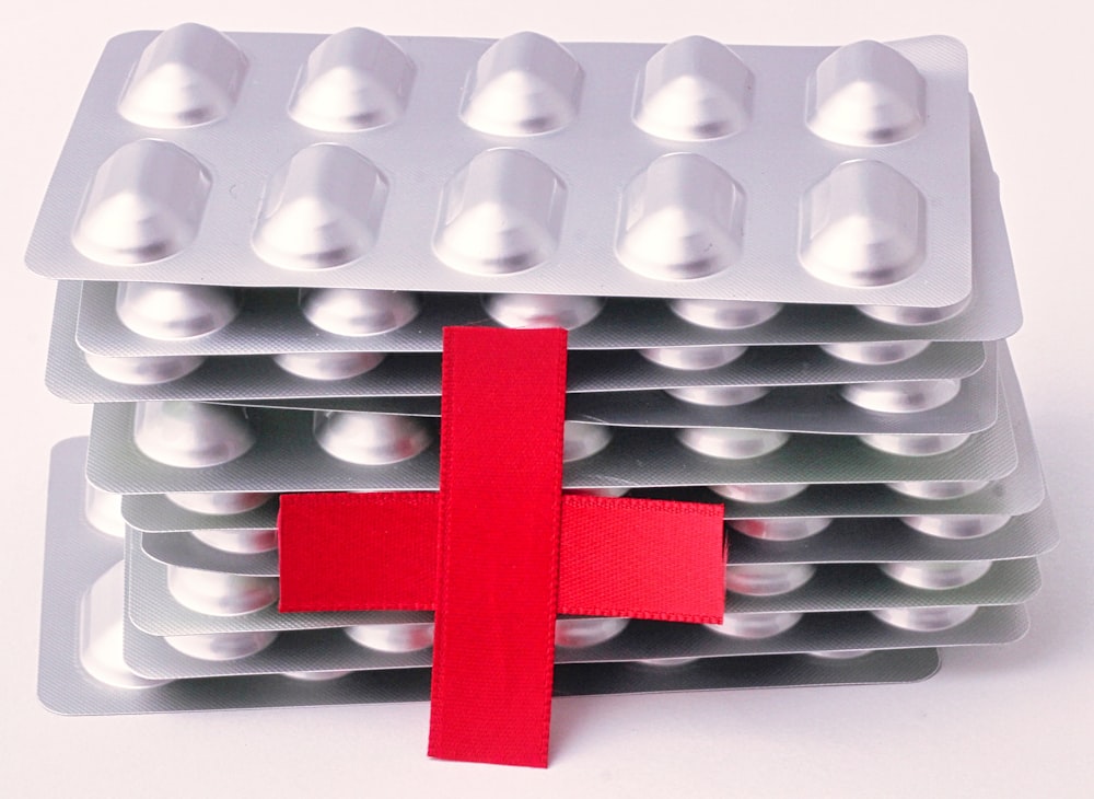 a red cross on top of a bunch of pills