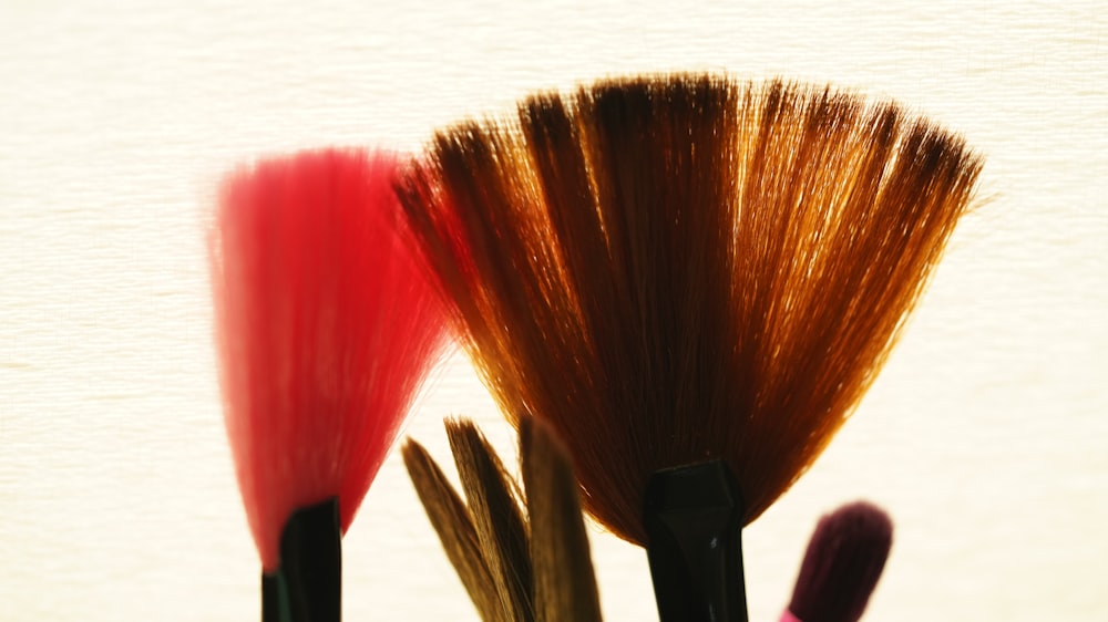 a close up of three brushes in a cup
