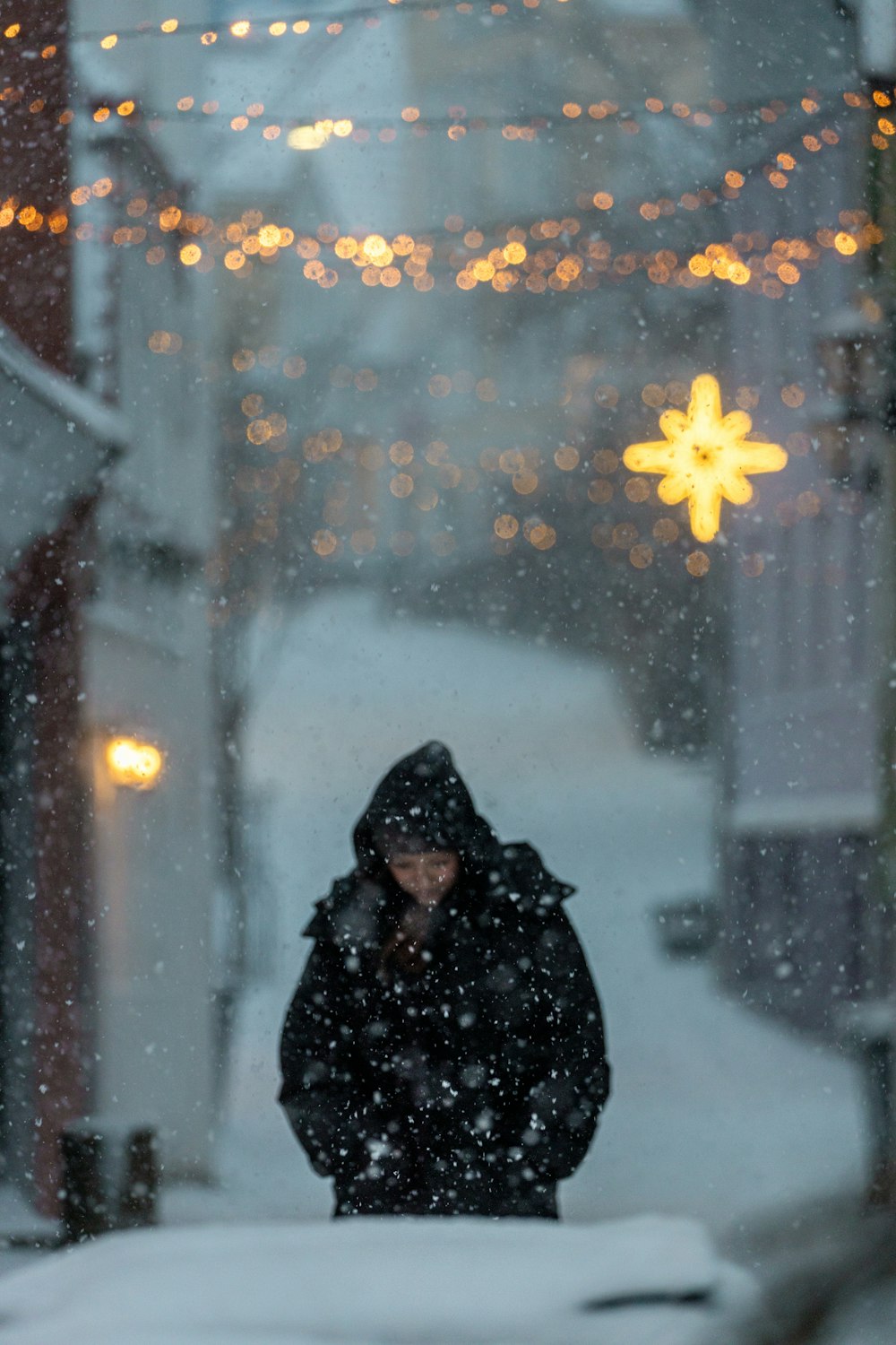 a person standing in the snow in front of a building