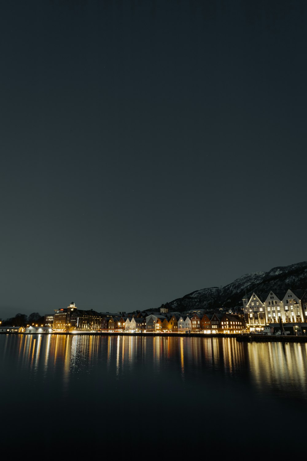 a night time view of a town on a lake