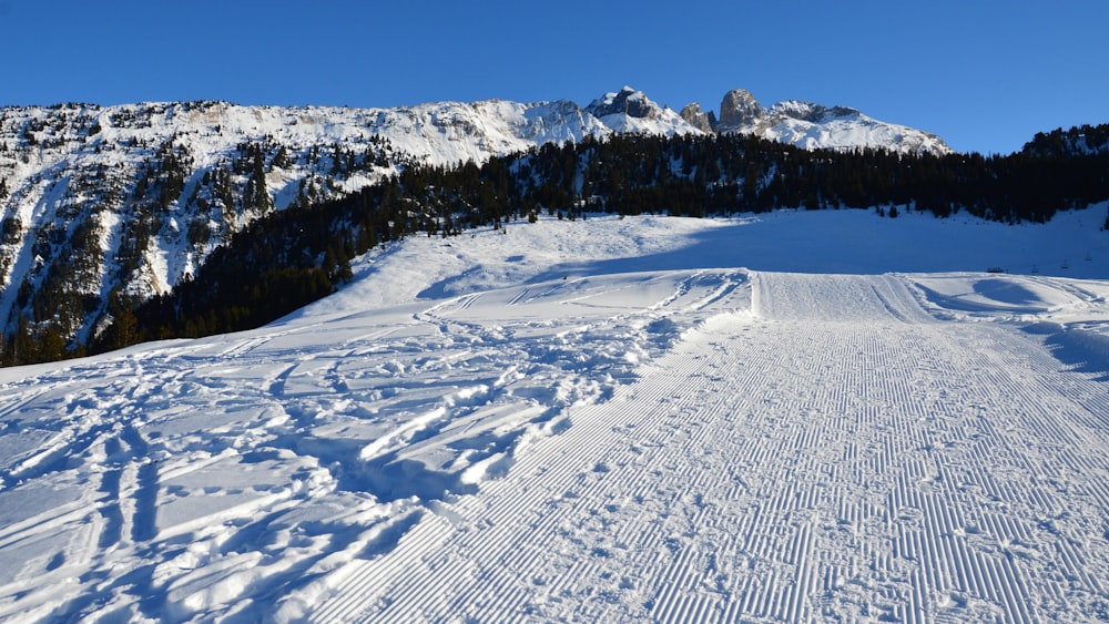 a snow covered ski slope with a mountain in the background