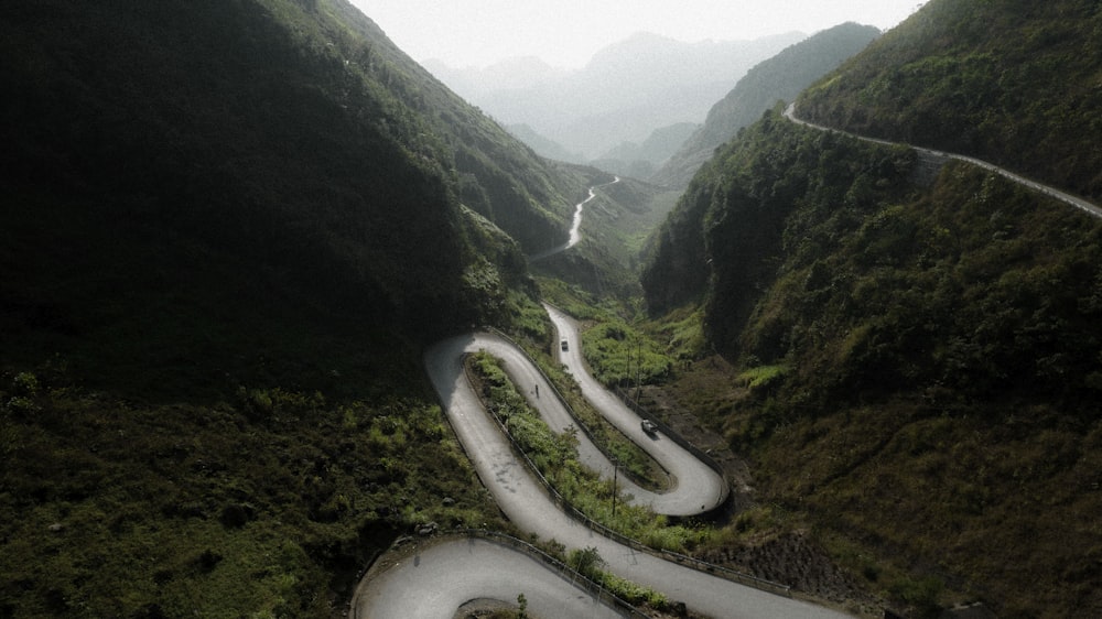 an aerial view of a winding road in the mountains