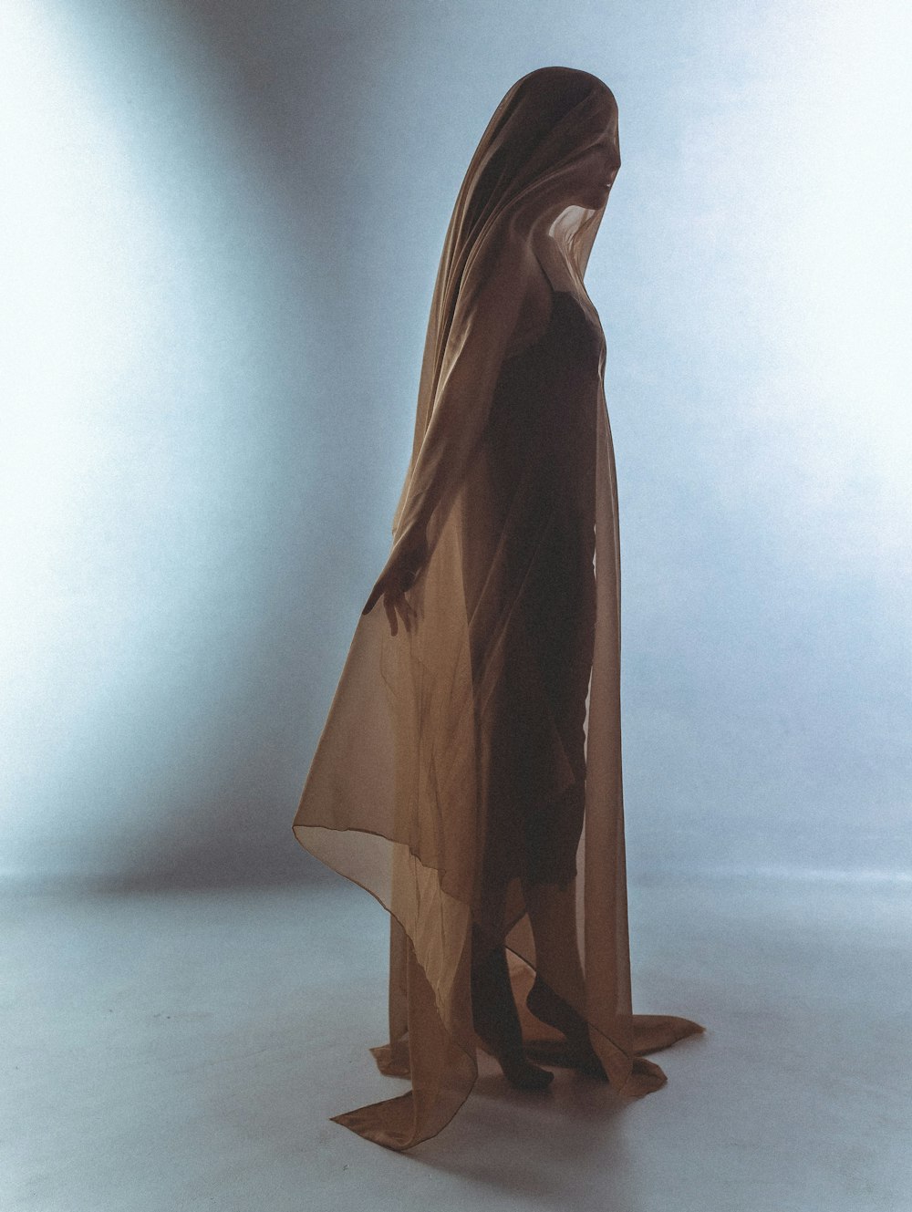 a woman in a brown dress standing in a white room