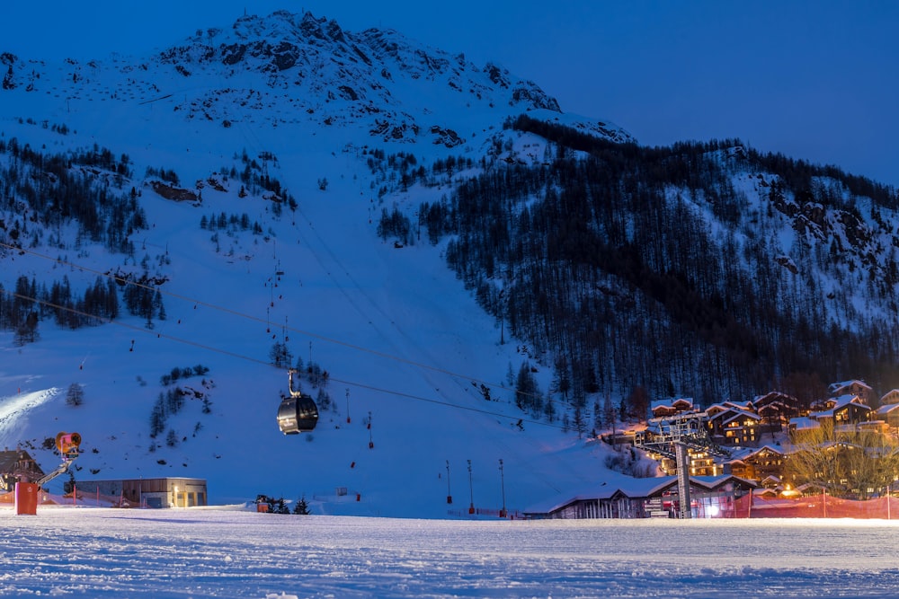 a ski lift going up a snowy mountain at night