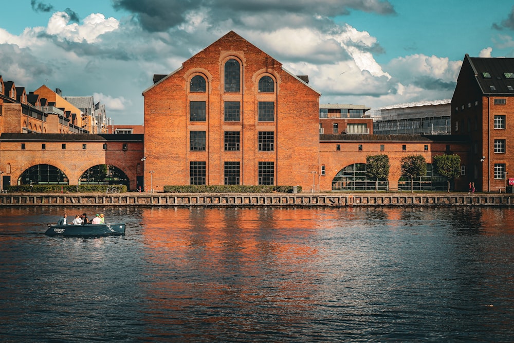 two people in a small boat in front of a brick building