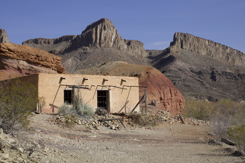 um edifício no deserto com montanhas ao fundo