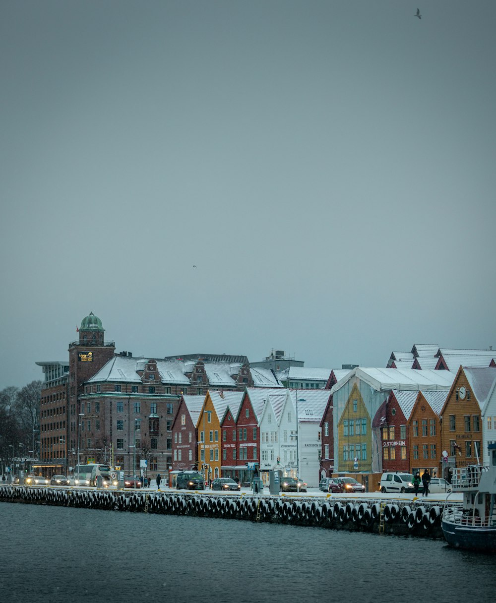 a row of colorful houses on the shore of a body of water