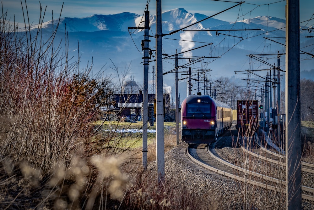 a train on a train track with mountains in the background