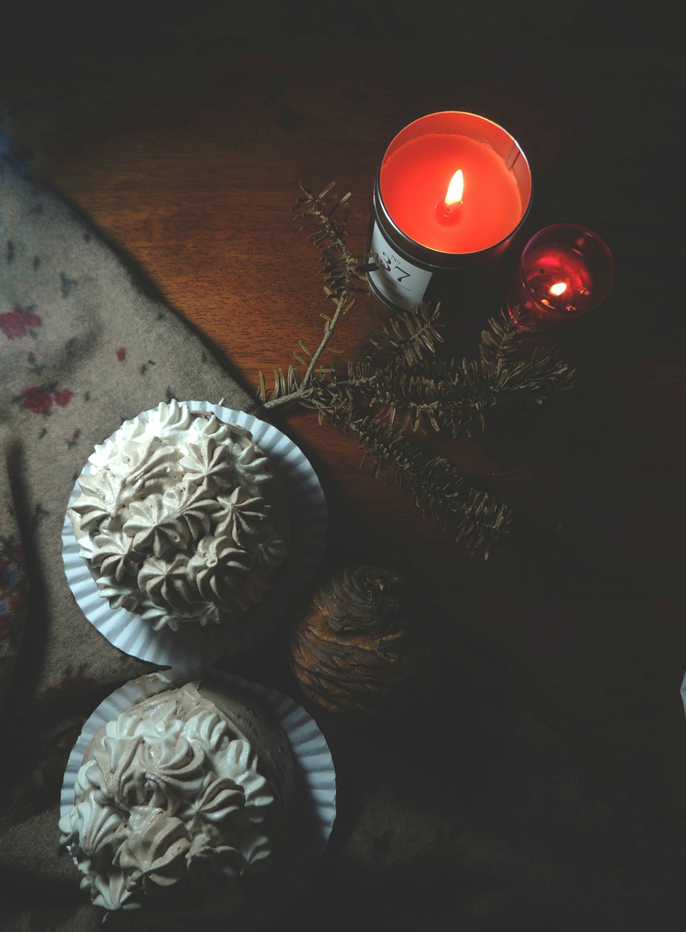 a couple of cupcakes sitting on top of a table next to a candle