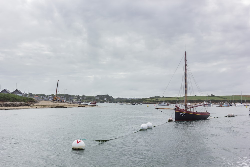 a sailboat is tied to a buoy in the water