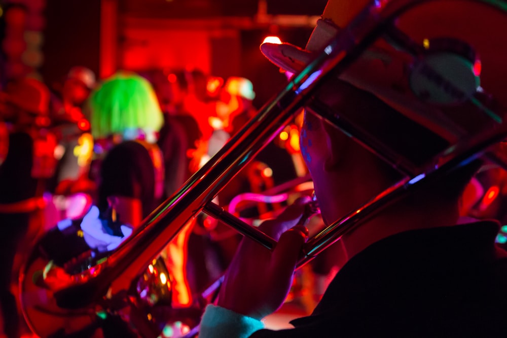 a person playing a trombone in a room full of people