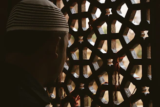 a man standing in front of a wooden fence