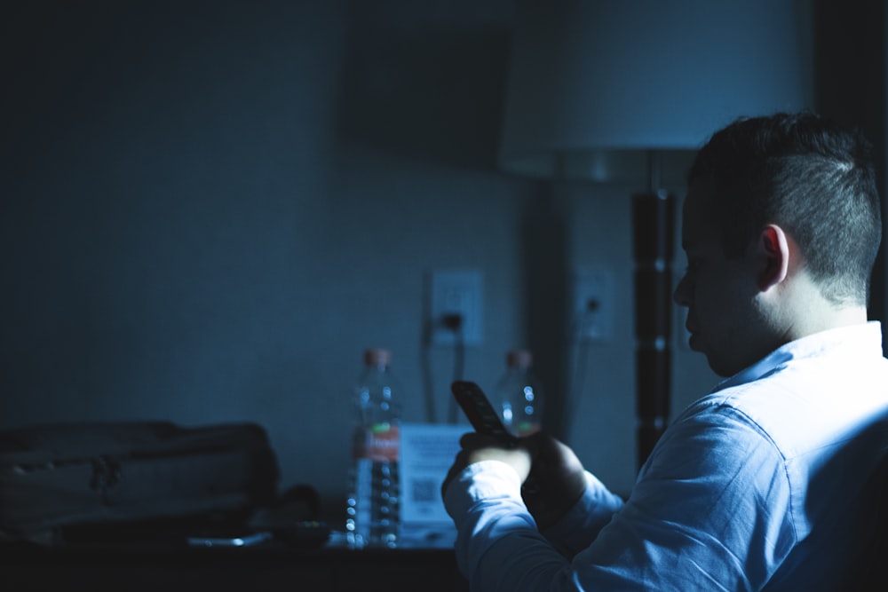 a man sitting in a chair holding a cell phone