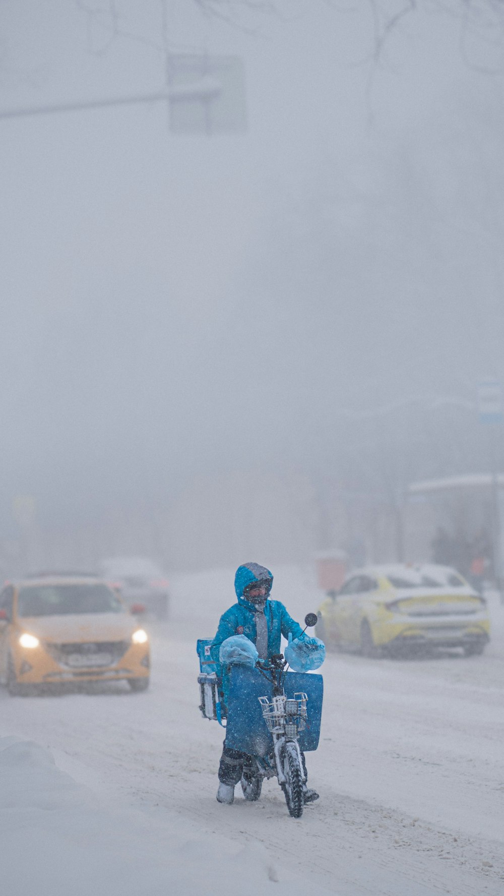 a man riding a bike down a snow covered street