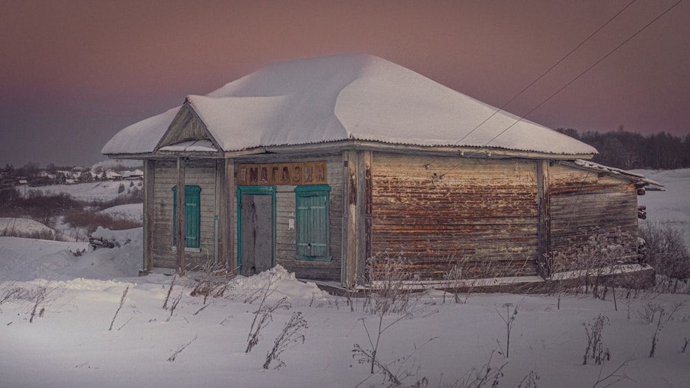 an old wooden building with a snow covered roof