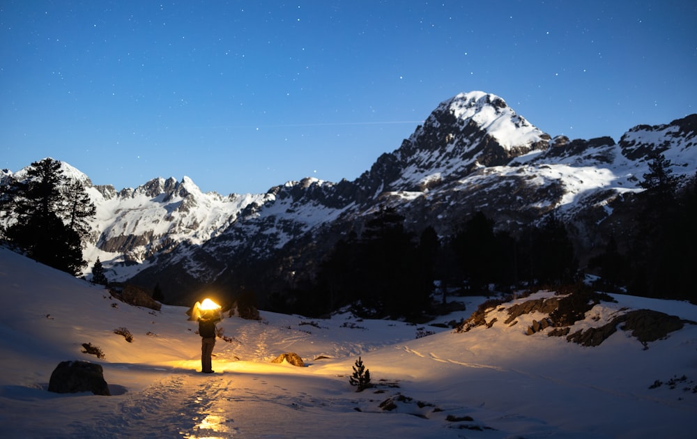 a person standing in the snow at night