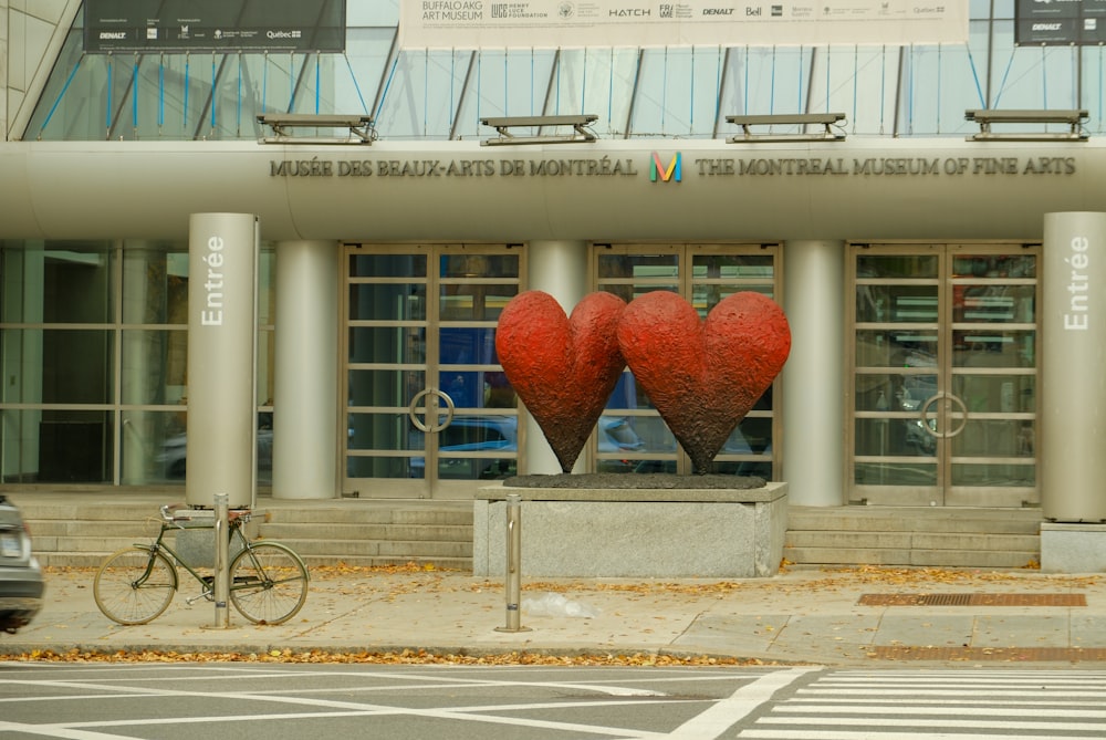 a couple of heart shaped sculptures in front of a building