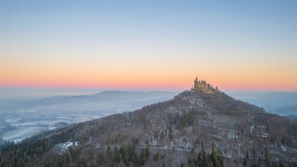 a castle on top of a mountain at sunset