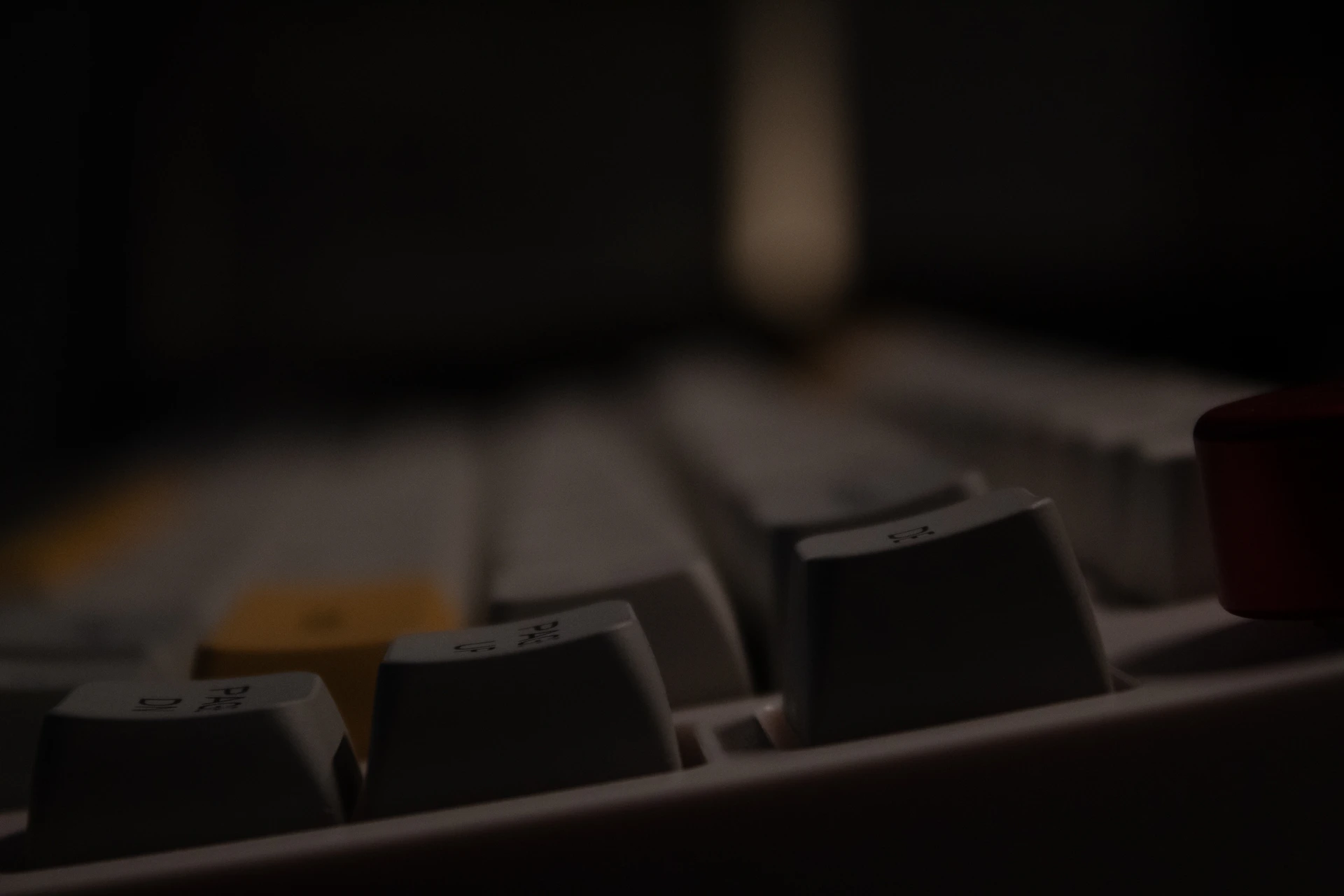 a close up of a computer keyboard in a dark room