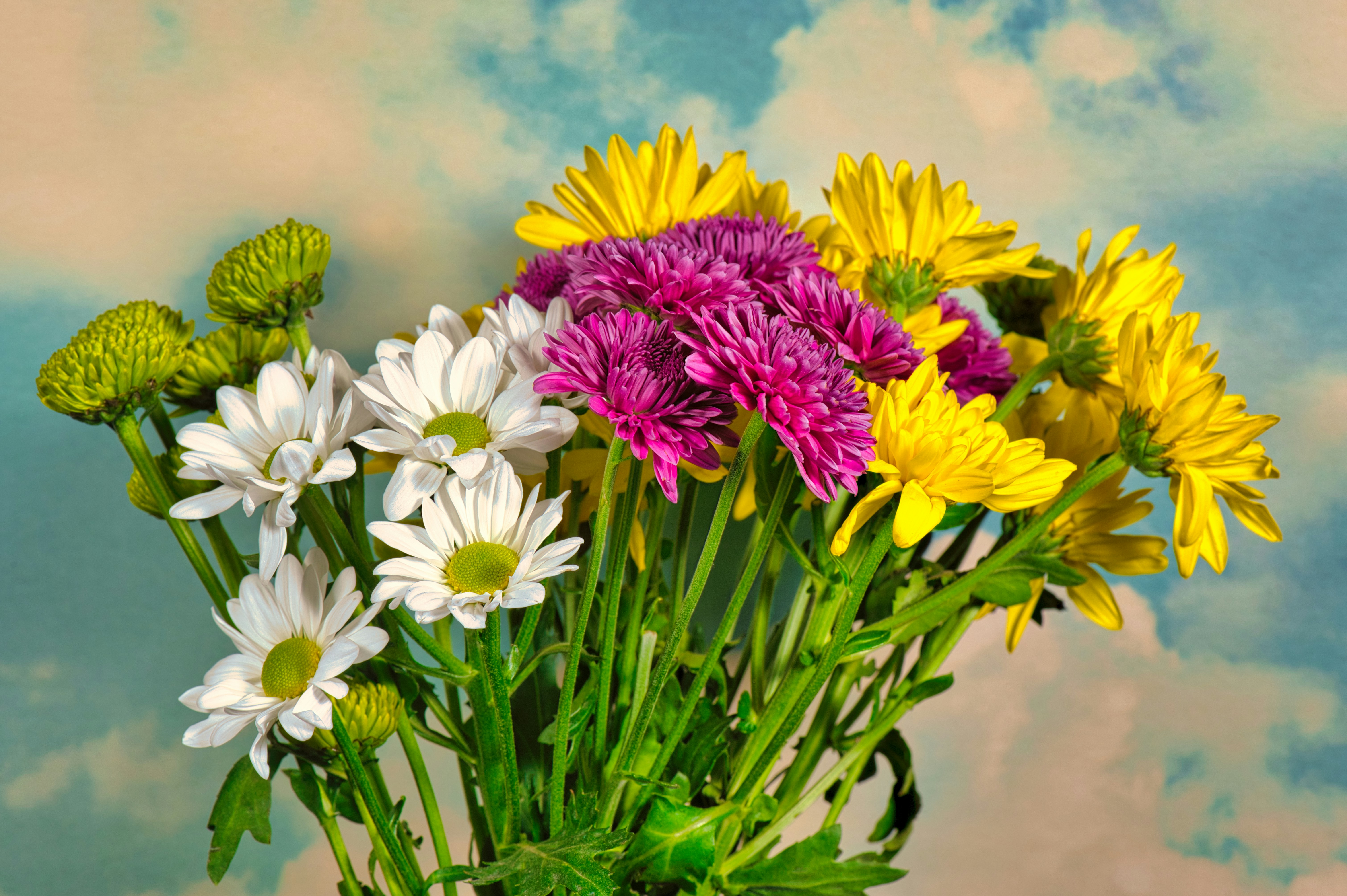 a vase filled with lots of different colored flowers
