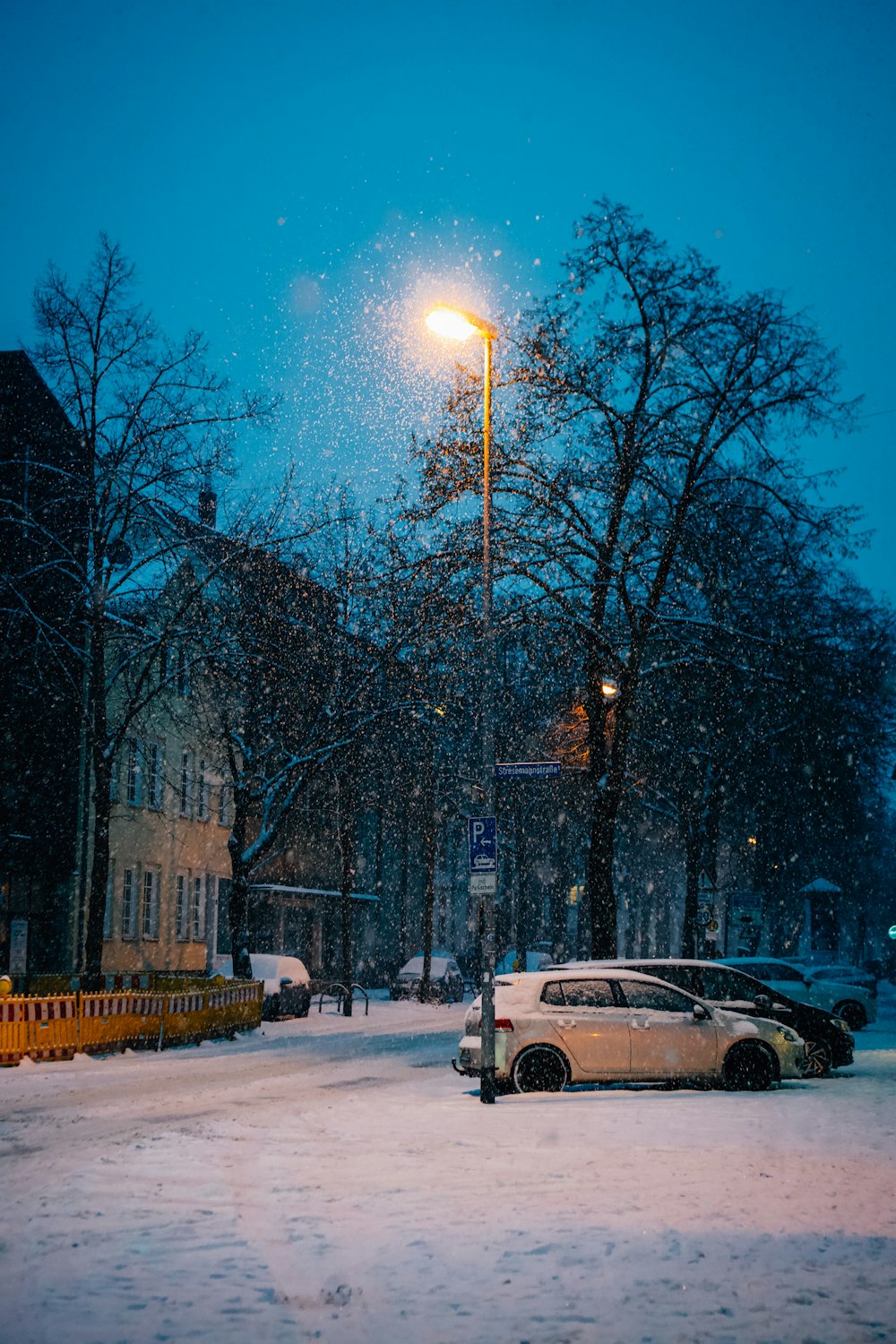 a car parked on a snowy street at night