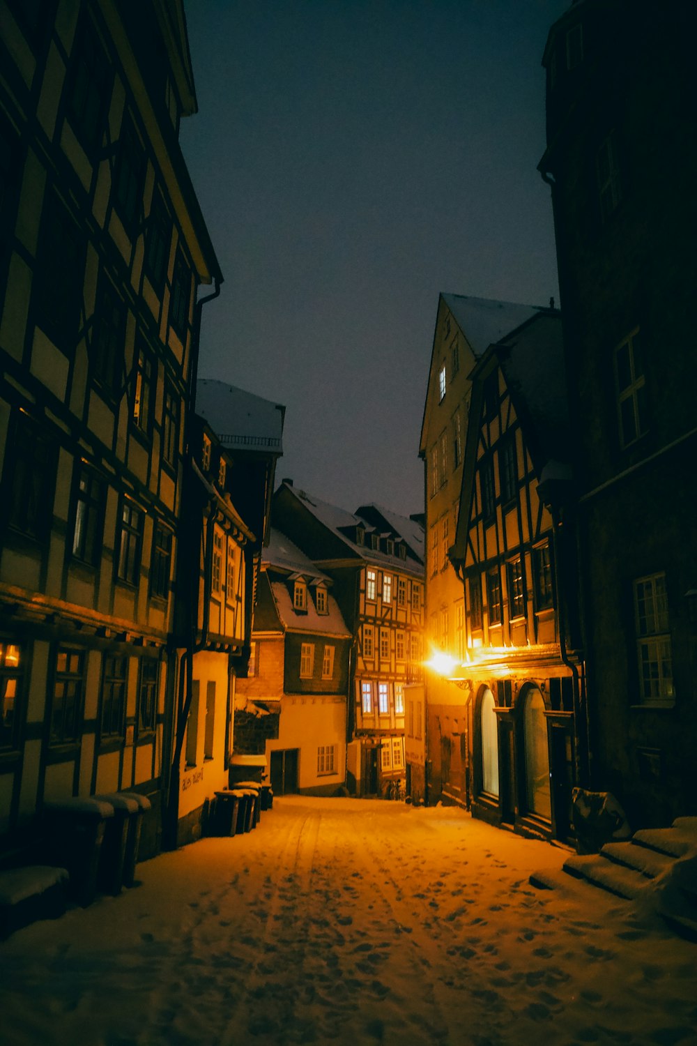 a dark street with buildings and a street light