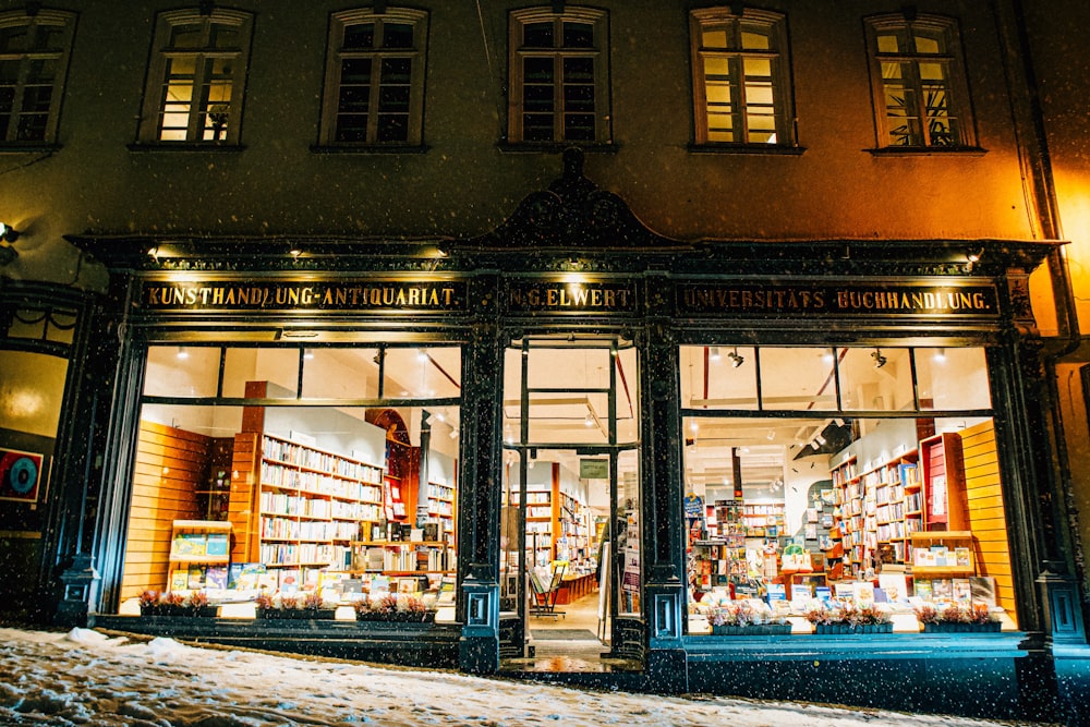 a store front at night with snow on the ground