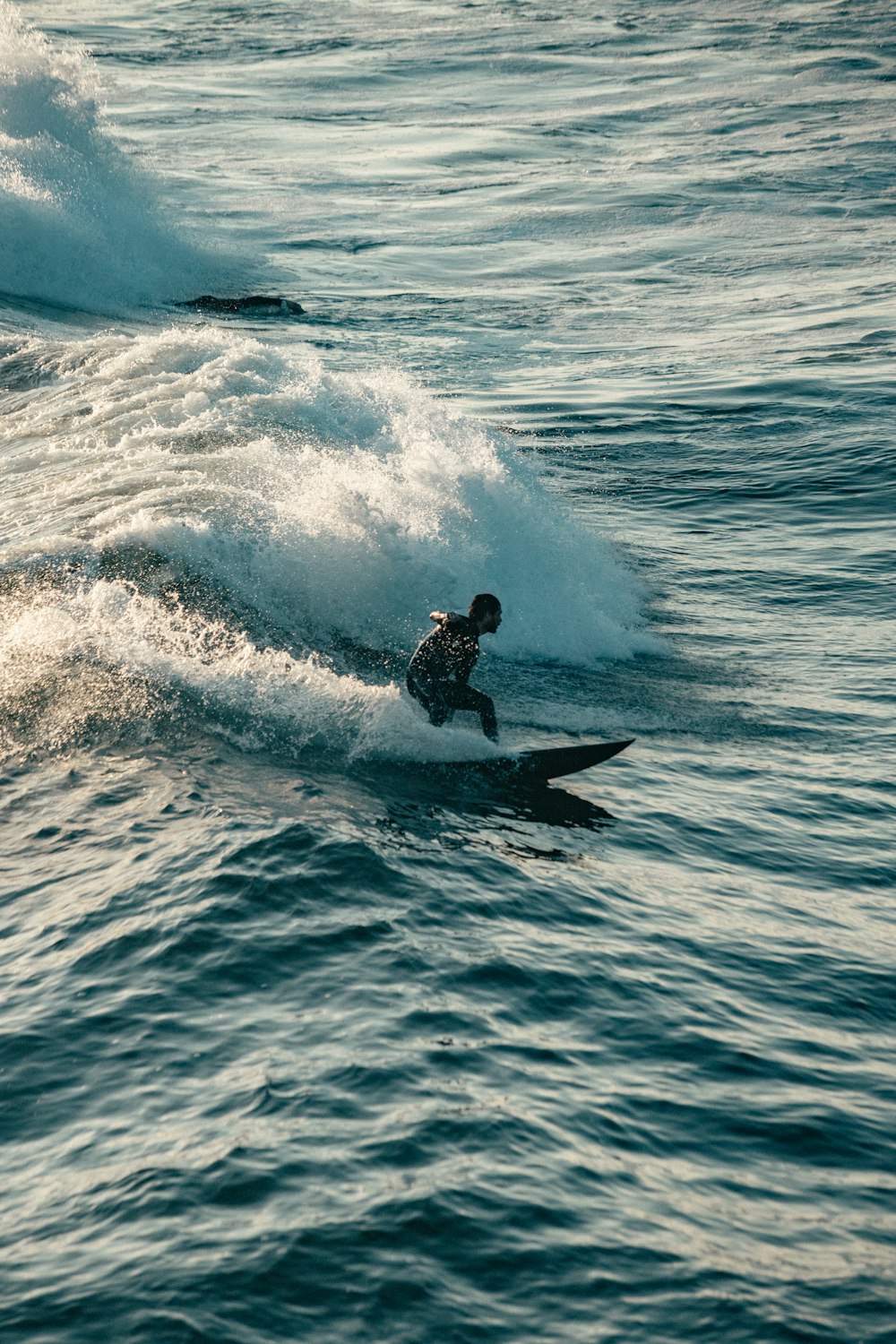 a man riding a wave on top of a surfboard