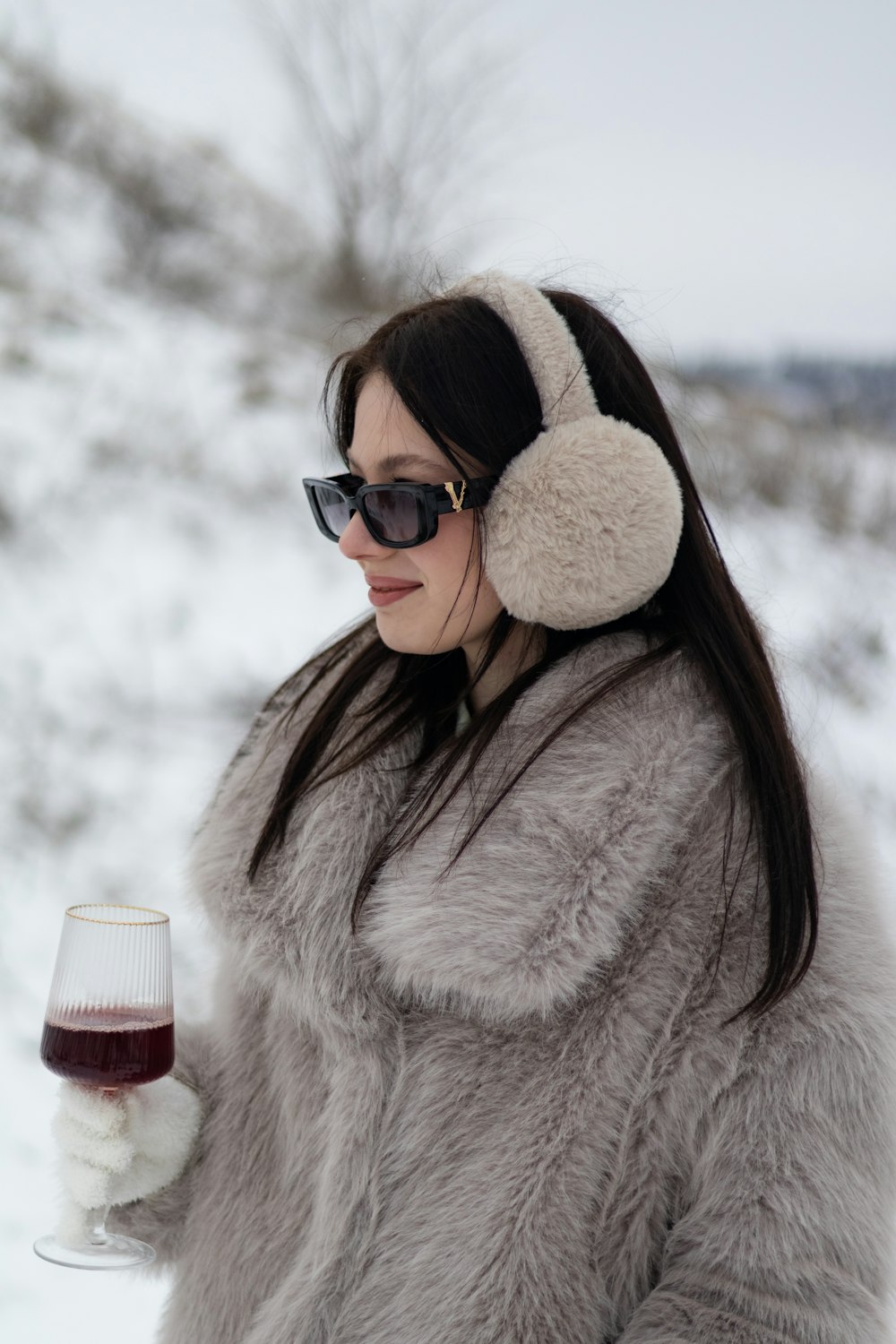 a woman wearing headphones holding a glass of wine