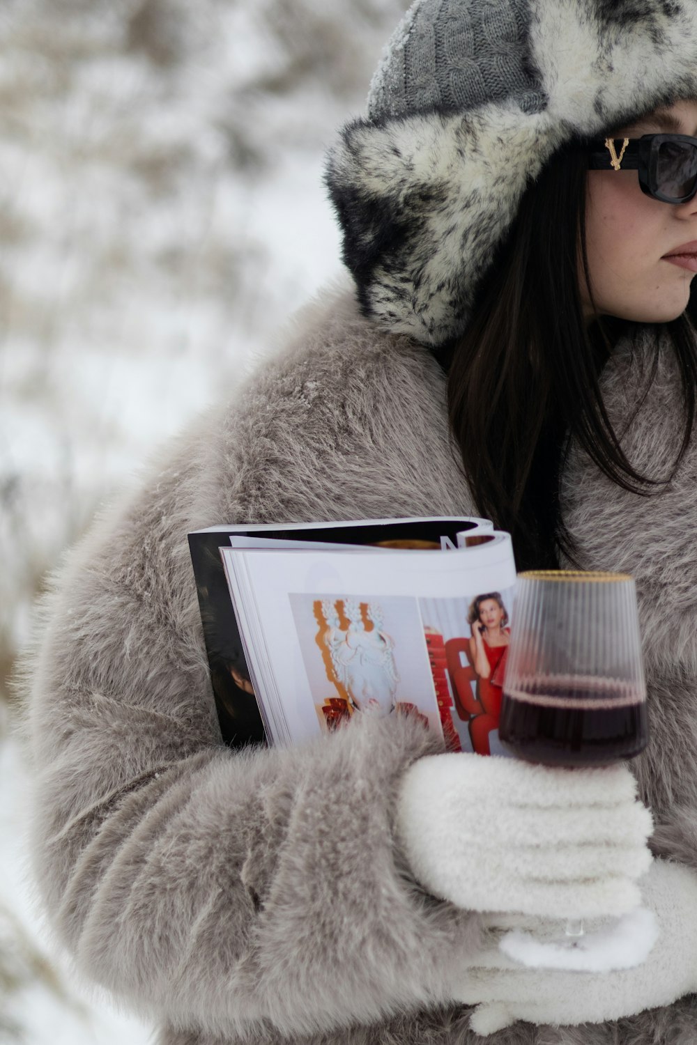 a woman holding a book and a glass of wine