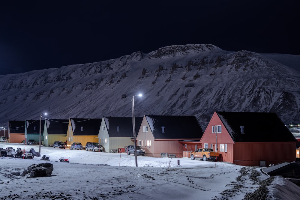 a group of houses sitting on top of a snow covered hillside