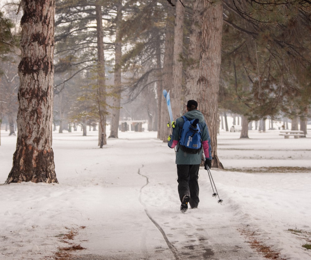 a person walking in the snow with skis