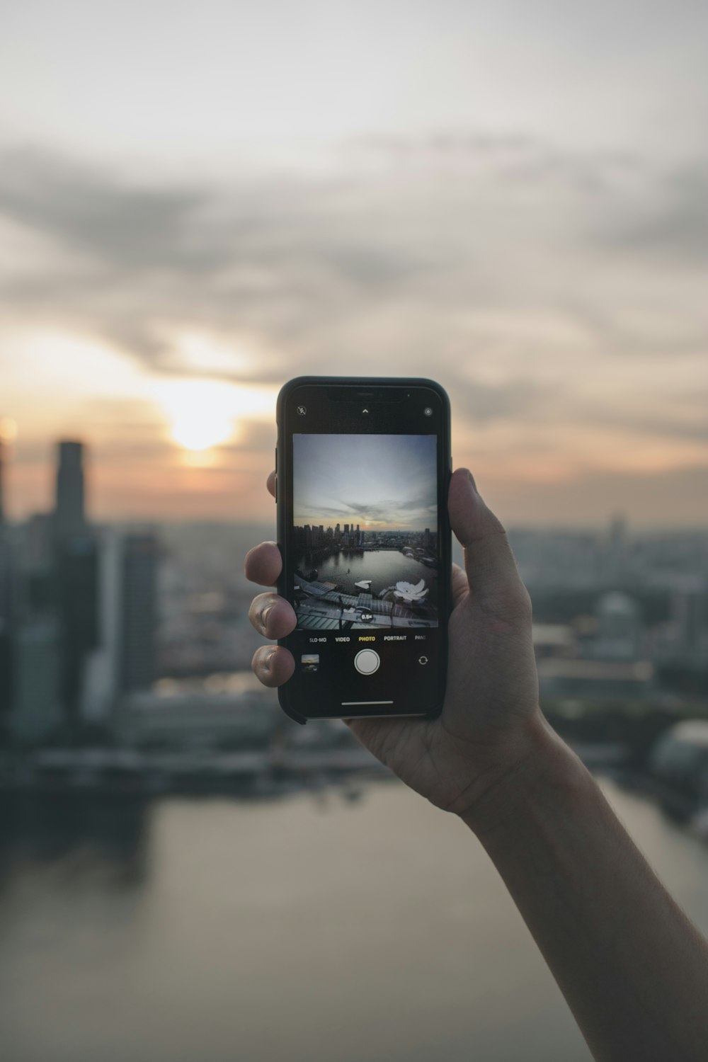 a person holding up a cell phone to take a picture