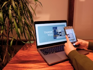 a person using a cell phone and laptop computer