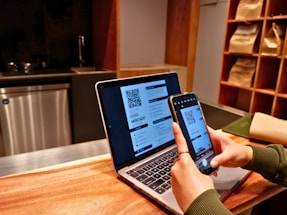 a person using a laptop and a cell phone