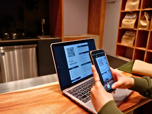 a person using a laptop and a cell phone