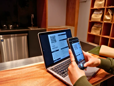 a person using a laptop and a cell phone