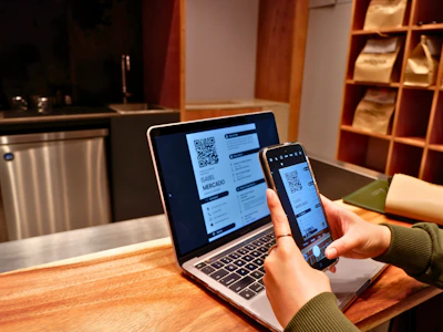 a person using a laptop and a cell phone