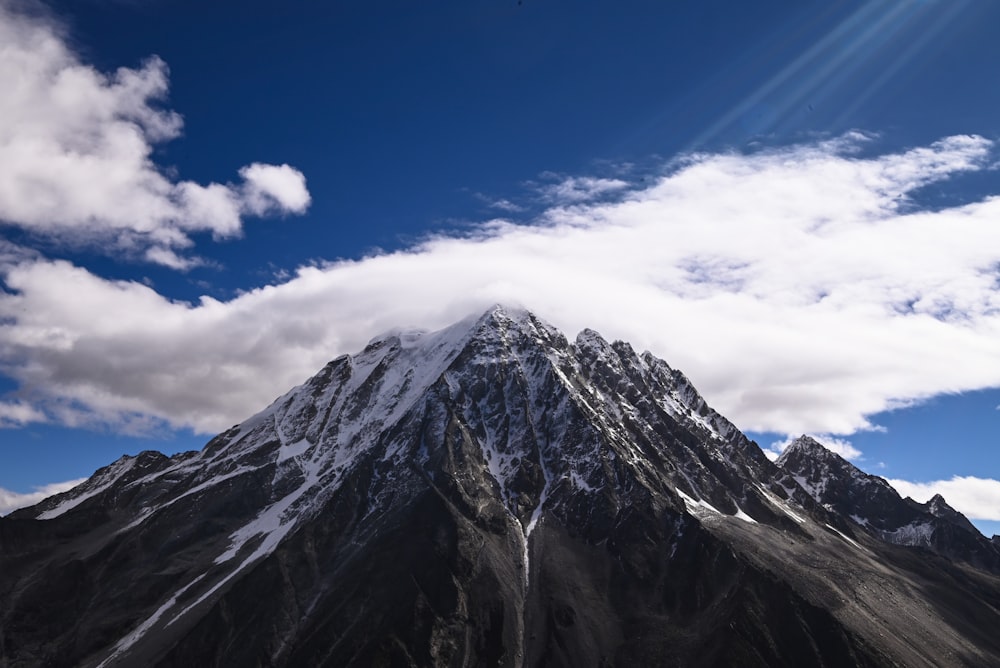 a snow covered mountain under a partly cloudy sky