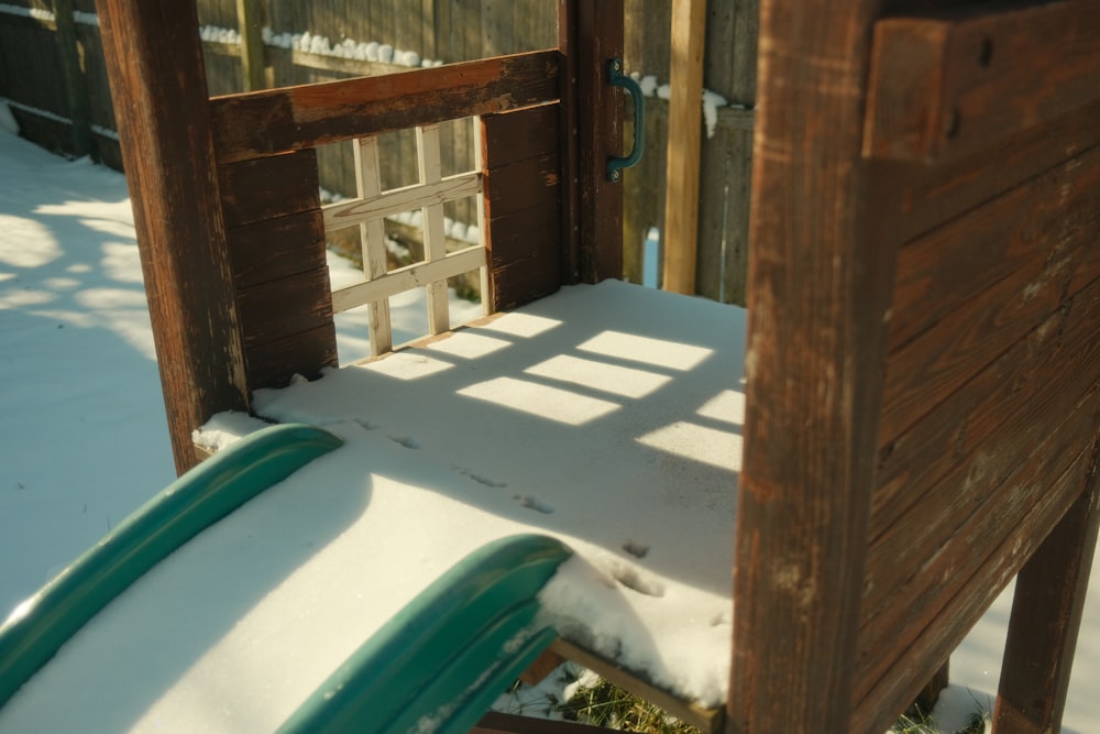 a sled in the snow next to a wooden fence