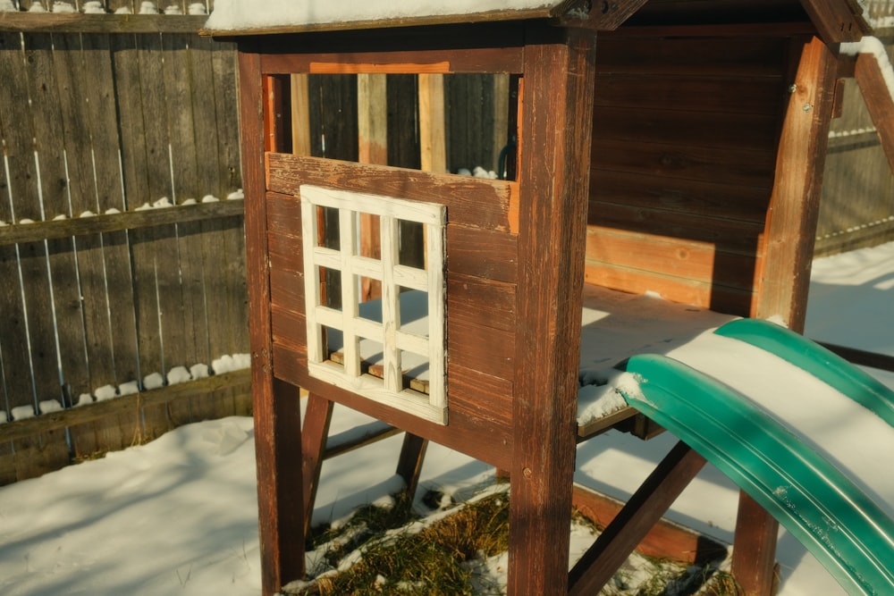 un patio cubierto de nieve con un trineo de nieve y una estructura de madera